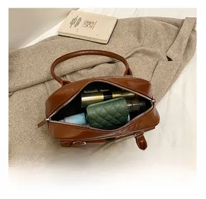 Detail showing the internal storage capacity of the brown PU leather handbag with zipper