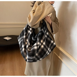 Vue détaillée du sac hobo à grands carreaux noir et blanc en tissu tweed élégant