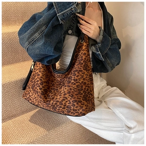 Détail du sac à bandoulière léopard avec fermeture dorée et finitions en cuir noir