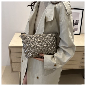 Détail de la pochette matelassée champagne avec finition satinée métallique et motif