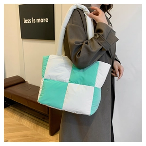 Quilted checkerboard tote bag in white and green shown worn by a model for size comparison
