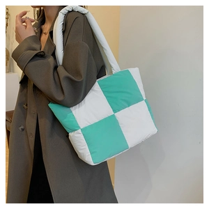 Quilted nylon tote bag in mint green and white check pattern shown on shoulder