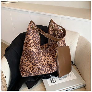 Ensemble sac cabas à imprimé léopard avec anses marron et pochette assortie sur fauteuil