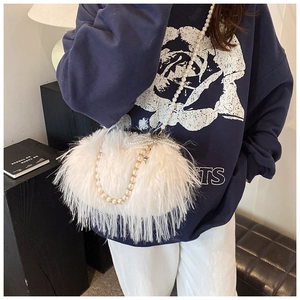 Detail of white faux fur shoulder bag with pearl beaded strap and bow ornament