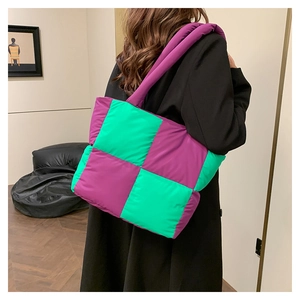 Detail of a large puffer nylon shoulder bag in purple and bright green checkered pattern