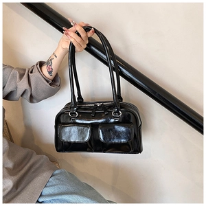 Detail of glossy black PU leather shoulder bag featuring dual front flap pockets and silver zipper