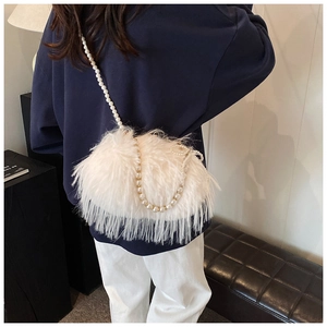 Detail of a white faux feather shoulder bag featuring a luxury pearl bead strap and gold hooks