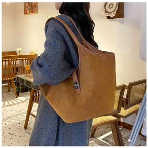Detail view of caramel faux suede tote bag showing soft texture and silver buckle