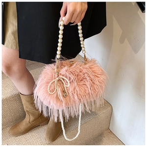 Pink plush feather handbag featuring white pearl handle and golden kiss lock clasp closure