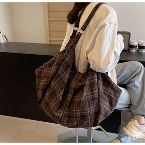 Détail d'un grand sac cabas à carreaux marron en toile avec anneau métallique réglable
