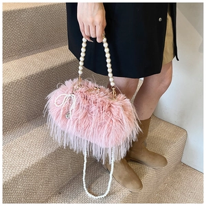Detail of soft pink faux fur handbag with pearl handle and bow decoration