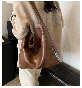 Detailed view of large brown vintage PU leather hobo bag with designer fabric label