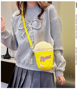 Detail of vibrant yellow popcorn bucket shaped crossbody bag with plush faux fur topping