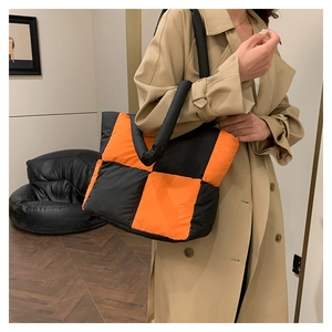 Detailed close-up of quilted nylon tote bag with bold orange and black checkerboard design