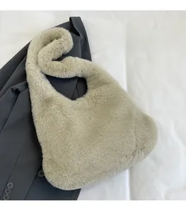 Vue détaillée du sac à bandoulière en fausse fourrure beige doux sur un costume gris