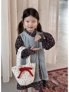 Close-up of girls autumn cotton floral dress with blue knit vest and matching handbag
