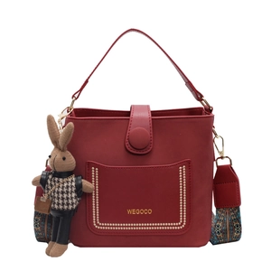 Dark red PU leather bucket bag with gold stud accents and floral woven shoulder strap