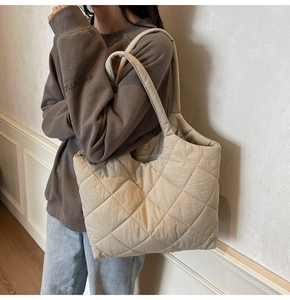 Detail of beige quilted puffer tote bag with diamond stitching shown on shoulder
