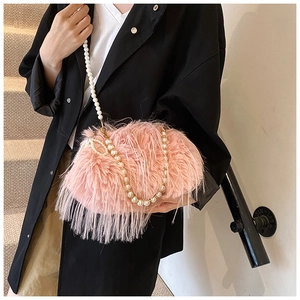 Detail of pink faux feather crossbody bag featuring an elegant large pearl strap handle