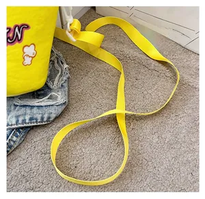 Detail of the bright yellow fabric bag featuring durable nylon strap and plastic hooks
