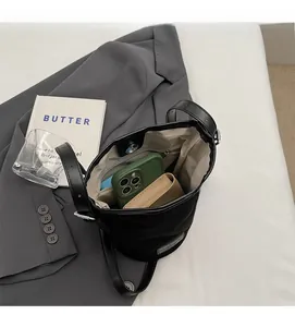 Top-down view of black matte bucket bag interior with compartments and ample space
