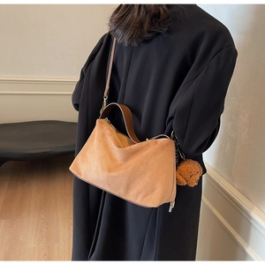 Brown faux suede dumpling bag with cute puppy charm accessory and crossbody strap
