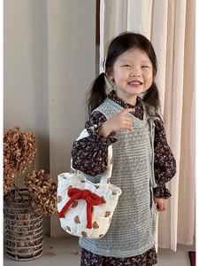 Close-up of quilted cotton children's handbag featuring brown bear prints and a red bow