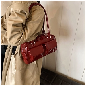 Deep red glossy PU shoulder bag with dual side pockets worn with an autumn trench coat