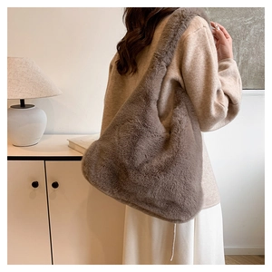Vue détaillée du sac à épaule en fausse fourrure marron café porté par un mannequin en intérieur