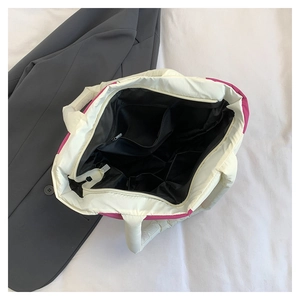 Top view of spacious interior with black lining and zipper pocket on quilted tote bag