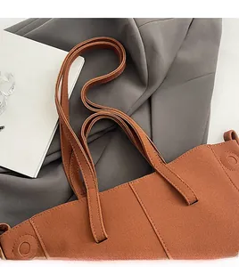 Close-up of terracotta PU suede tote bag with flat handles and vertical stitching