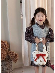 Detail of a white bear quilted handbag with red bow accent and matching girl outfits