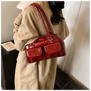 Detail view of burgundy retro underarm bag with double front pockets on the model