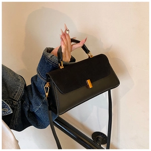 Detail view of black PU leather shoulder bag with suede flap and gold metal lock