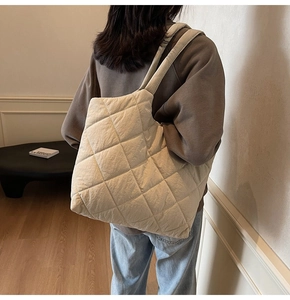 Detail view of beige quilted shoulder bag featuring classic rhombic stitching pattern