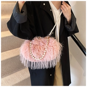 Detailed view of pink feather bag featuring elegant pearl shoulder strap and metal clasp