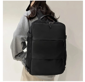 Detail of black waterproof nylon backpack featuring side compression straps and thick handle