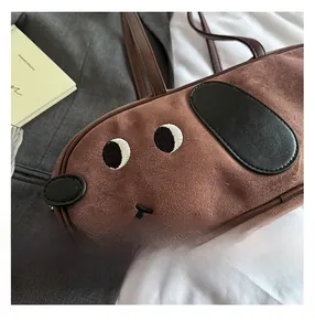 Détail de sac à bandoulière en daim marron en forme de chien avec broderie et oreilles
