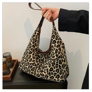Detail of leopard print tote bag with brown leather handles and spacious interior