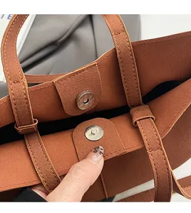 Detail shot of the magnetic snap closure on a brown matte leather minimalist handbag