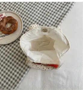 Detailed interior of polka dot canvas bag showing silver magnetic closure and single compartment