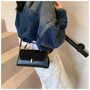Detailed look at the black matte PU leather crossbody bag worn with a casual outfit