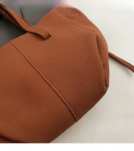 Detailed close-up of brown PU leather tote bag with reinforced double stitching and soft texture