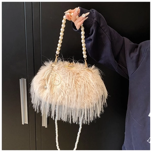 Detailed close-up of cream plush feather evening bag with pearl chain and gold kiss lock