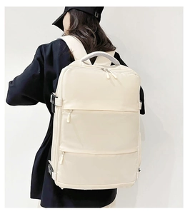 Rear view of a beige large-capacity travel backpack showing size and fit on model