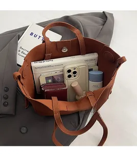 Top-down view of a spacious brown PU tote bag showing interior capacity with essentials