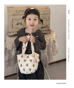 Détail d'un sac à bandoulière en coton matelassé avec imprimés ours et dentelle