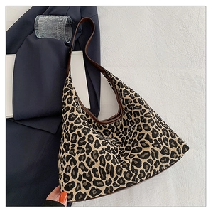 Chic leopard print woven shoulder bag with brown leather trim against a stylish background