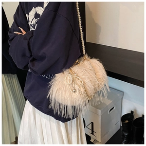 Detail of plush feather shoulder bag with pearl bow decoration and long pearl strap