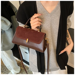 Detail of dark brown PU leather crossbody bag with contrasting matte suede flap